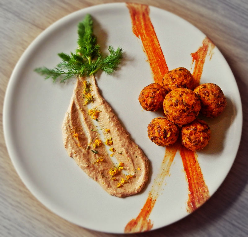 Polpettine crudiste disposte a stella su un piatto bianco, al di sotto due strisce di salsa arancione, accanto una cucchiaiata spalmata di salsa