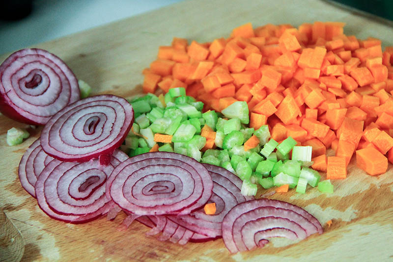 Su un tagliere Cipolle sedano e carote.