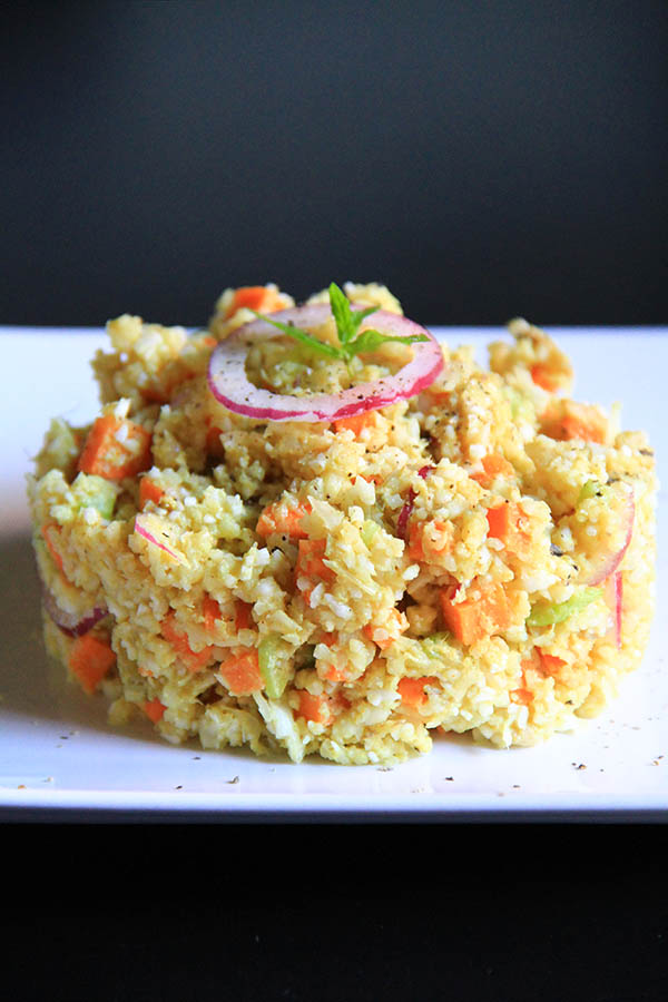 Al centro di un piatto bianco un tortino di cous cous di verdure.
