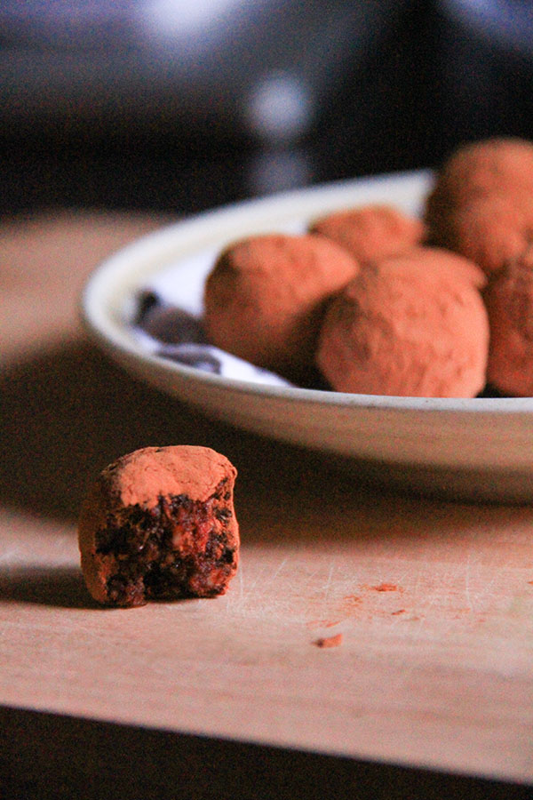 Alcuni Tartufi crudisti alla carruba all'interno di un piatto, in primo piano un tartufo mangiato per metà.