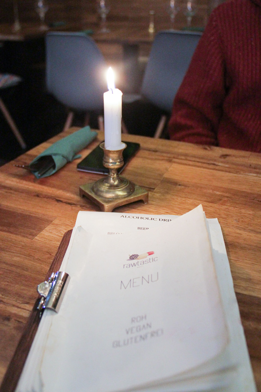 Menù su tavolo di legno, illuminato da candela